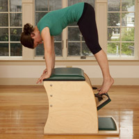 A woman practicing pilates on a Wunda Chair